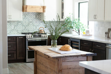 Farmhouse ceramic tile kitchen photo in Phoenix with a farmhouse sink, shaker cabinets, solid surface countertops, multicolored backsplash, cement tile backsplash, stainless steel appliances, an island and yellow countertops
