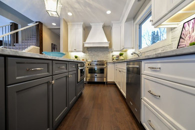 Inspiration for a mid-sized contemporary l-shaped dark wood floor and brown floor enclosed kitchen remodel in Calgary with recessed-panel cabinets, white cabinets, marble countertops, multicolored backsplash, matchstick tile backsplash, stainless steel appliances, an island and an undermount sink