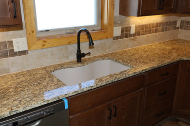 Mid-sized trendy u-shaped vinyl floor and brown floor eat-in kitchen photo in Denver with an undermount sink, shaker cabinets, dark wood cabinets, granite countertops, beige backsplash, ceramic backsplash, colored appliances and beige countertops