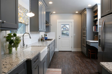 Example of a mid-sized arts and crafts galley kitchen design in Seattle with a farmhouse sink, shaker cabinets, gray cabinets, quartzite countertops, white backsplash, subway tile backsplash, stainless steel appliances and no island