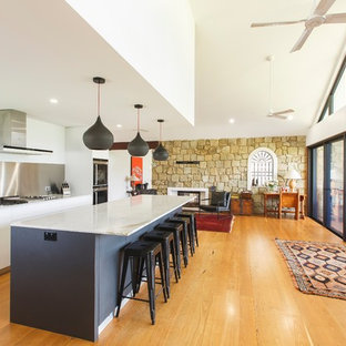Mid-sized contemporary galley kitchen in Newcastle - Maitland with a drop-in sink, flat-panel cabinets, marble benchtops, medium hardwood floors, brown floor, white benchtop and with island.