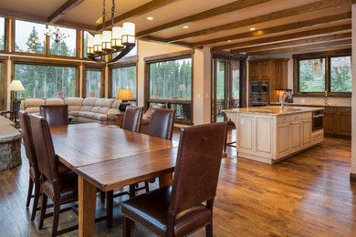 Mountain style l-shaped light wood floor and beige floor open concept kitchen photo in Denver with an undermount sink, beaded inset cabinets, white cabinets, granite countertops, beige backsplash, stainless steel appliances and an island