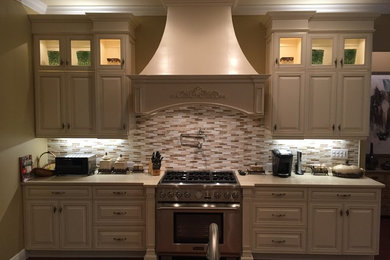 Ejemplo de cocina clásica con armarios con paneles con relieve, puertas de armario beige, encimera de cuarzo compacto, salpicadero multicolor y salpicadero de azulejos de vidrio