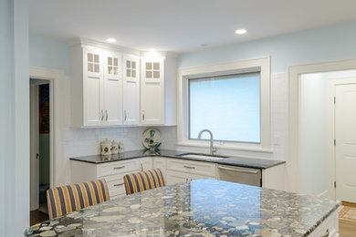 Cette photo montre une cuisine chic avec des portes de placard blanches et un plan de travail en granite.