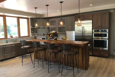 Example of a large minimalist l-shaped medium tone wood floor and gray floor open concept kitchen design in Denver with shaker cabinets, dark wood cabinets, an island, stainless steel appliances, a double-bowl sink, marble countertops, multicolored backsplash, marble backsplash and multicolored countertops