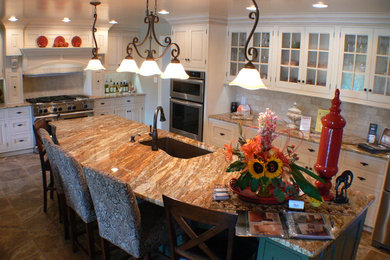 Küche mit Unterbauwaschbecken, Granit-Arbeitsplatte, Rückwand aus Steinfliesen, Küchengeräten aus Edelstahl und Kücheninsel in Sonstige