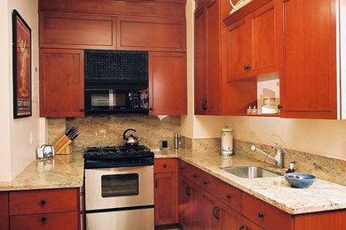 This is an example of a small classic galley enclosed kitchen in New York with a submerged sink, recessed-panel cabinets, medium wood cabinets, granite worktops, beige splashback, stone slab splashback, integrated appliances, porcelain flooring and no island.