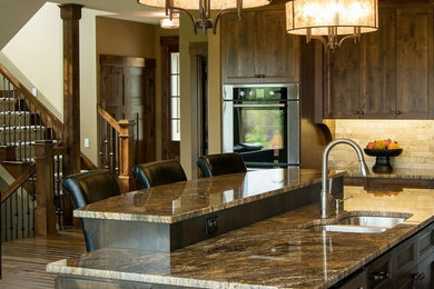 Example of a l-shaped dark wood floor eat-in kitchen design in Minneapolis with an undermount sink, recessed-panel cabinets, dark wood cabinets, granite countertops, beige backsplash, stone tile backsplash, stainless steel appliances and an island