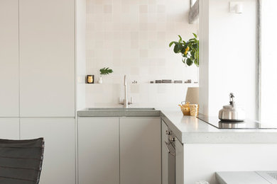 Imagen de cocina gris y blanca contemporánea con armarios con paneles lisos, puertas de armario blancas y salpicadero beige