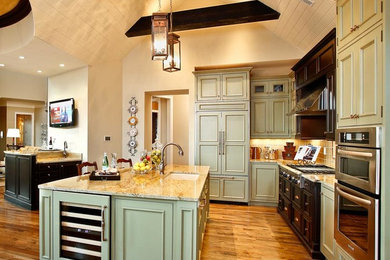 Inspiration for a transitional l-shaped medium tone wood floor open concept kitchen remodel in Other with an undermount sink, beaded inset cabinets, green cabinets, granite countertops, ceramic backsplash, stainless steel appliances and an island