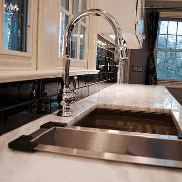 Goose neck chrome faucet with tile back splash and granite tops.