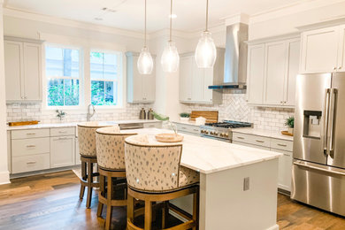 Mid-sized transitional l-shaped brown floor eat-in kitchen photo in Other with a farmhouse sink, shaker cabinets, gray cabinets, quartz countertops, gray backsplash, ceramic backsplash, stainless steel appliances, an island and white countertops