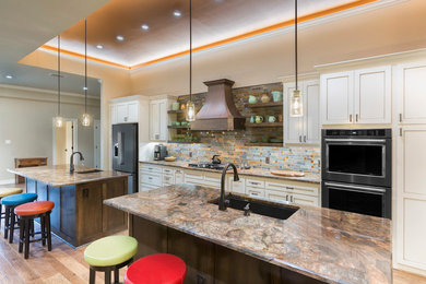 Inspiration for a mid-sized transitional l-shaped medium tone wood floor and beige floor open concept kitchen remodel in Dallas with an undermount sink, shaker cabinets, white cabinets, granite countertops, multicolored backsplash, slate backsplash, stainless steel appliances and an island