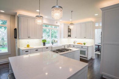 Kitchen photo in Seattle with white cabinets, a farmhouse sink, white backsplash, white appliances and an island