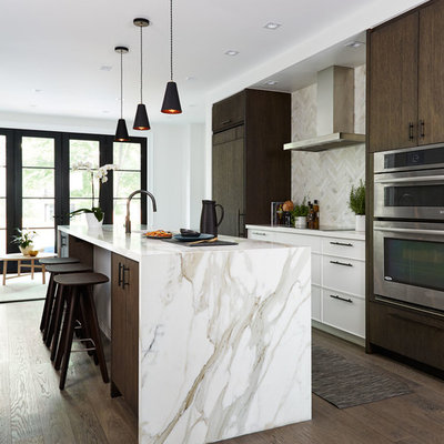 Mid-sized trendy dark wood floor and brown floor open concept kitchen photo in Toronto with an undermount sink, flat-panel cabinets, marble countertops, marble backsplash, an island, paneled appliances, beige backsplash and beige countertops