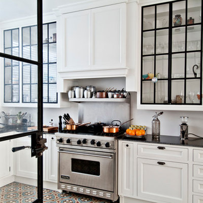 Inspiration for a contemporary l-shaped enclosed kitchen remodel in Los Angeles with a farmhouse sink, glass-front cabinets, white cabinets, stainless steel appliances, soapstone countertops and white backsplash