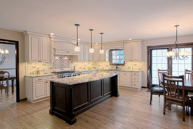 Inspiration for a large transitional u-shaped dark wood floor and brown floor eat-in kitchen remodel in Chicago with raised-panel cabinets, white cabinets, granite countertops, ceramic backsplash, stainless steel appliances, an island, a drop-in sink and gray backsplash