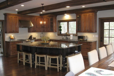 ワシントンD.C.にある高級な広いラスティックスタイルのおしゃれなキッチン (レイズドパネル扉のキャビネット、中間色木目調キャビネット、御影石カウンター、シルバーの調理設備、無垢フローリング) の写真
