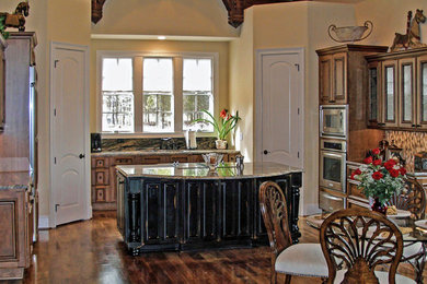 Eat-in kitchen - large transitional u-shaped dark wood floor eat-in kitchen idea in Charlotte with an undermount sink, raised-panel cabinets, granite countertops, brown backsplash, ceramic backsplash, stainless steel appliances and distressed cabinets