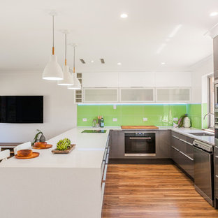 Design ideas for a contemporary u-shaped open plan kitchen in Perth with an undermount sink, flat-panel cabinets, grey cabinets, green splashback, glass sheet splashback, stainless steel appliances, dark hardwood floors, a peninsula and white benchtop.