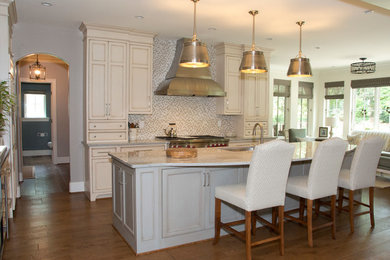 Example of a large transitional l-shaped enclosed kitchen design in Philadelphia with an undermount sink, white cabinets, multicolored backsplash, ceramic backsplash, stainless steel appliances and an island
