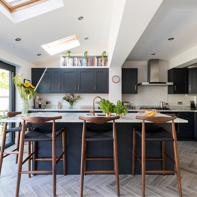 Kitchen - mid-sized contemporary l-shaped gray floor kitchen idea in London with recessed-panel cabinets, blue cabinets, marble countertops, white backsplash, subway tile backsplash, stainless steel appliances and a peninsula