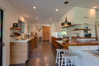 Foto på ett stort funkis brun kök, med släta luckor, skåp i ljust trä, marmorbänkskiva, vitt stänkskydd, rostfria vitvaror, en köksö, en enkel diskho, stänkskydd i marmor, klinkergolv i keramik och grått golv
