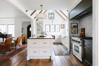 Inspiration for a mid-sized country l-shaped dark wood floor open concept kitchen remodel in Grand Rapids with a farmhouse sink, recessed-panel cabinets, white backsplash, subway tile backsplash, an island, white cabinets, stainless steel appliances and wood countertops