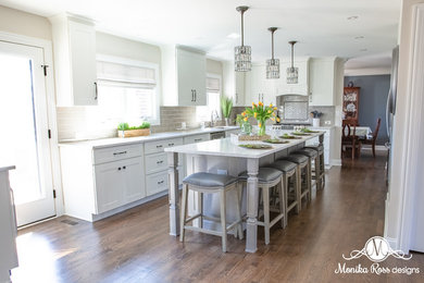 Inspiration for a large transitional u-shaped medium tone wood floor and brown floor open concept kitchen remodel in Chicago with an undermount sink, shaker cabinets, white cabinets, quartz countertops, gray backsplash, ceramic backsplash, stainless steel appliances, an island and white countertops
