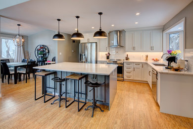 This is an example of a large traditional l-shaped open plan kitchen in Edmonton with a submerged sink, recessed-panel cabinets, grey cabinets, engineered stone countertops, white splashback, ceramic splashback, stainless steel appliances, cork flooring, an island, brown floors and grey worktops.