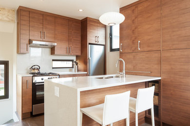 Eat-in kitchen - small contemporary galley medium tone wood floor and gray floor eat-in kitchen idea in Vancouver with flat-panel cabinets, medium tone wood cabinets, a peninsula, quartz countertops, white backsplash, stainless steel appliances and a double-bowl sink