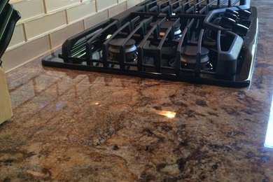 サクラメントにある中くらいなトラディショナルスタイルのおしゃれなキッチン (アンダーカウンターシンク、御影石カウンター、ガラスタイルのキッチンパネル、黒い調理設備) の写真