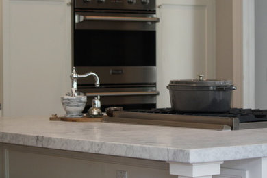 サクラメントにあるトラディショナルスタイルのおしゃれなキッチン (アンダーカウンターシンク、落し込みパネル扉のキャビネット、白いキャビネット、大理石カウンター) の写真