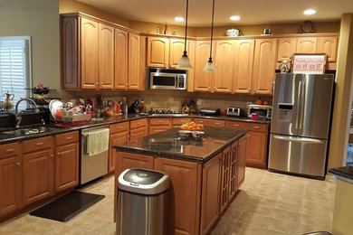 Example of a mid-sized classic l-shaped ceramic tile and beige floor eat-in kitchen design in DC Metro with a double-bowl sink, raised-panel cabinets, medium tone wood cabinets, granite countertops, beige backsplash, ceramic backsplash, stainless steel appliances and an island