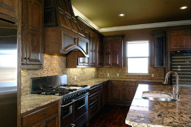 ダラスにある広いおしゃれなアイランドキッチン (濃色木目調キャビネット、御影石カウンター) の写真