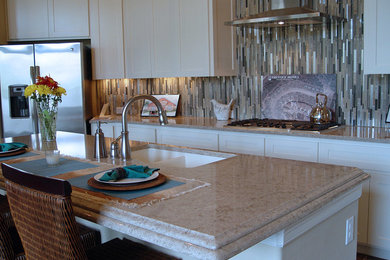 Inspiration for a large transitional l-shaped kitchen remodel in Austin with an undermount sink, shaker cabinets, white cabinets, granite countertops, multicolored backsplash, glass tile backsplash, stainless steel appliances and an island