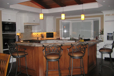 granite, painted cabinets with stained island, vaulted ceiling with false beams