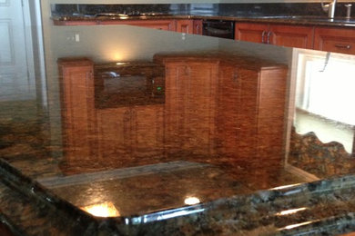 Cette photo montre une cuisine américaine linéaire moderne de taille moyenne avec un plan de travail en granite et îlot.