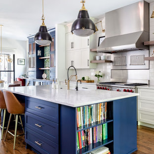 Transitional eat-in kitchen ideas - Example of a transitional brown floor, medium tone wood floor and exposed beam eat-in kitchen design in Atlanta with a farmhouse sink, shaker cabinets, white cabinets, white backsplash, subway tile backsplash, stainless steel appliances, an island, white countertops and quartz countertops