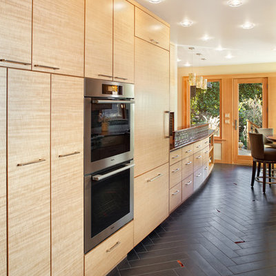 Trendy kitchen photo in Portland with stainless steel appliances, flat-panel cabinets and medium tone wood cabinets