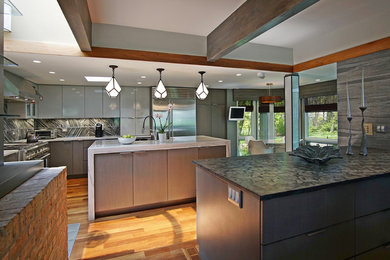 Inspiration for a mid-sized contemporary l-shaped medium tone wood floor eat-in kitchen remodel in Chicago with a farmhouse sink, flat-panel cabinets, gray cabinets, marble countertops, multicolored backsplash, porcelain backsplash, stainless steel appliances and an island