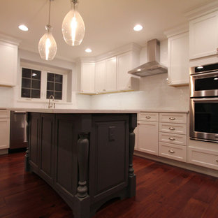 Inspiration for a large cottage l-shaped medium tone wood floor eat-in kitchen remodel in Philadelphia with a farmhouse sink, shaker cabinets, white cabinets, white backsplash, stainless steel appliances, an island, quartzite countertops and subway tile backsplash