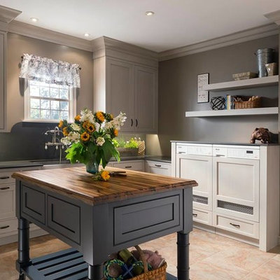 Mid-sized eclectic u-shaped ceramic tile kitchen pantry photo in Houston with a drop-in sink, beige cabinets, solid surface countertops, ceramic backsplash, stainless steel appliances and an island