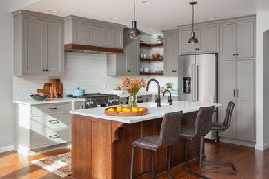 Kitchen - mid-sized transitional l-shaped medium tone wood floor and brown floor kitchen idea in Seattle with an undermount sink, shaker cabinets, gray cabinets, quartz countertops, white backsplash, subway tile backsplash, stainless steel appliances, an island and white countertops