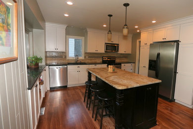 Mid-sized transitional u-shaped medium tone wood floor and brown floor eat-in kitchen photo in Kansas City with an undermount sink, white cabinets, granite countertops, beige backsplash, stone tile backsplash, stainless steel appliances, an island and shaker cabinets