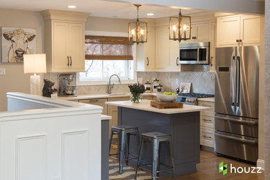 Inspiration for a transitional u-shaped medium tone wood floor and brown floor open concept kitchen remodel with an undermount sink, shaker cabinets, gray backsplash, stainless steel appliances, an island and beige cabinets