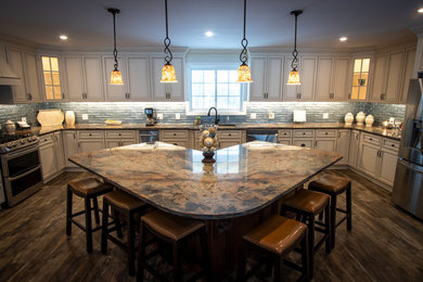 Large transitional u-shaped open concept kitchen photo in Other with granite countertops, an island and multicolored countertops
