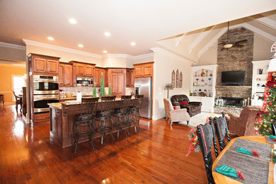 Eat-in kitchen - mid-sized traditional l-shaped dark wood floor and brown floor eat-in kitchen idea in Atlanta with raised-panel cabinets, dark wood cabinets, granite countertops, an island, beige backsplash, ceramic backsplash and stainless steel appliances