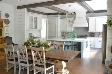 Large farmhouse l-shaped dark wood floor and brown floor open concept kitchen photo in Atlanta with recessed-panel cabinets, white cabinets, solid surface countertops, an island, gray backsplash, subway tile backsplash, stainless steel appliances and an undermount sink