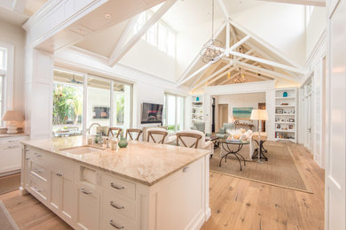 Inspiration for a large cottage light wood floor open concept kitchen remodel in Tampa with a farmhouse sink, shaker cabinets, white cabinets, marble countertops, white backsplash, ceramic backsplash, paneled appliances and an island